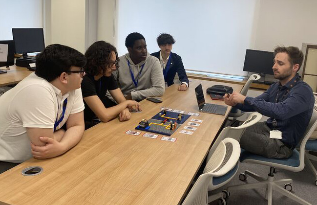 A photograph of a police officer addressing a group of college students