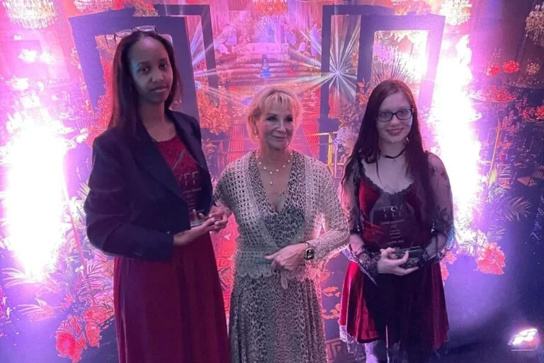 A photograph of Julia von klonowski with two stdudents alongside, at the award ceremony